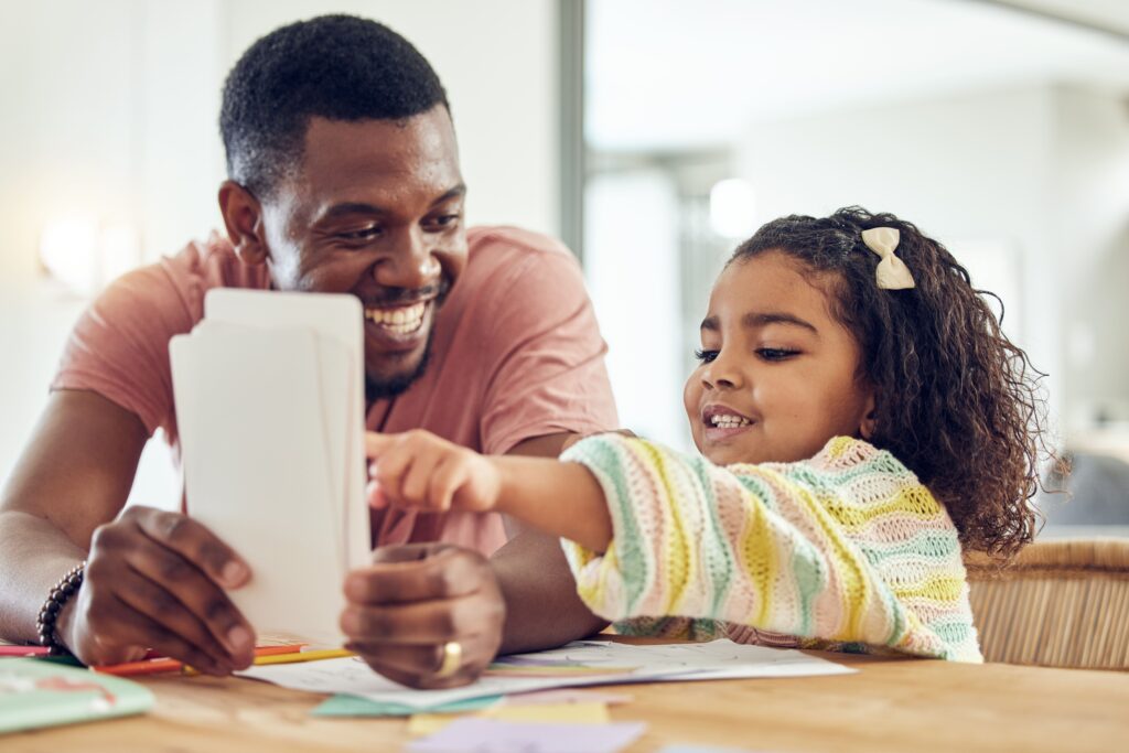 Father helping a daughter learn to read with flashcards